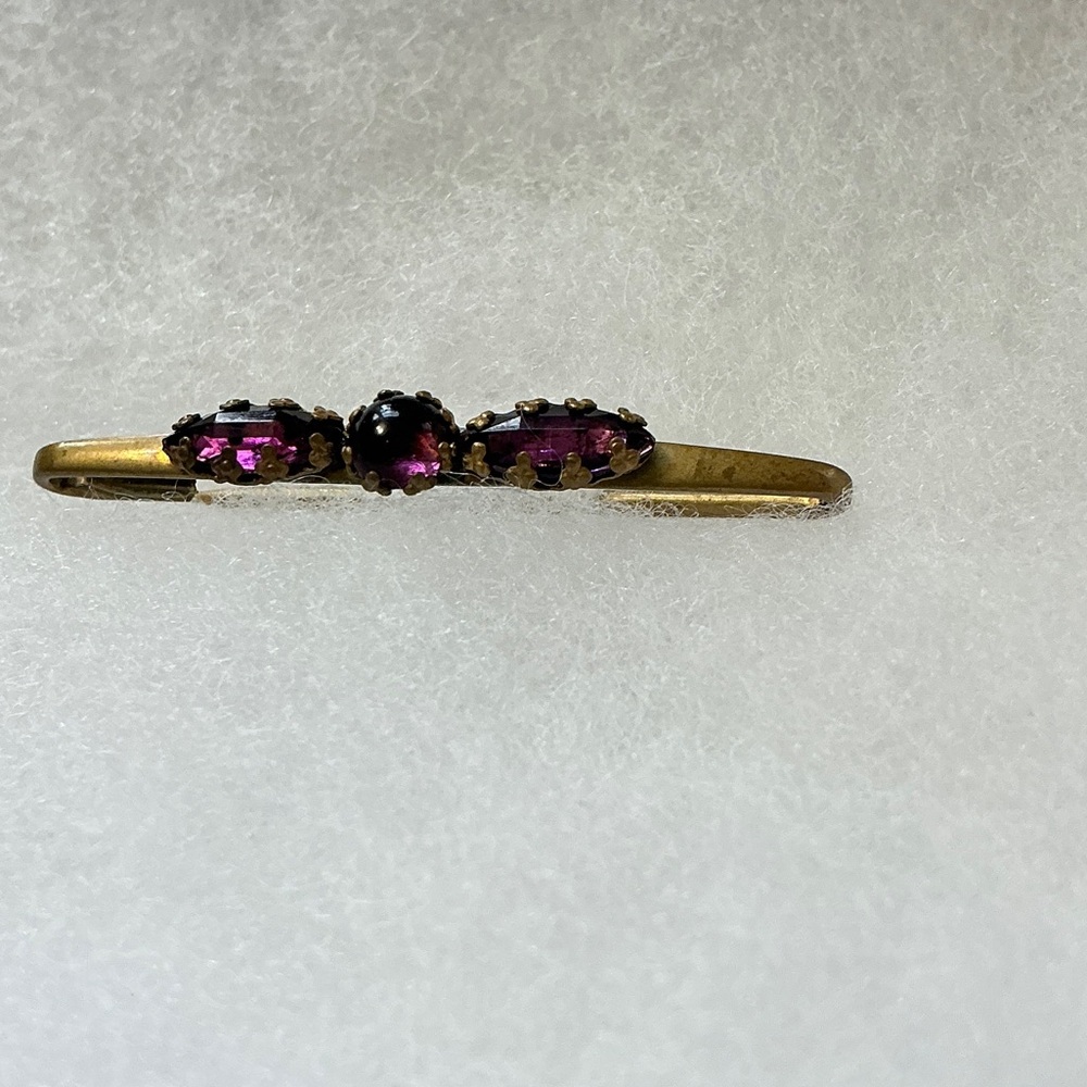 Vintage gold tone pin set with purple tone or amethyst stones.